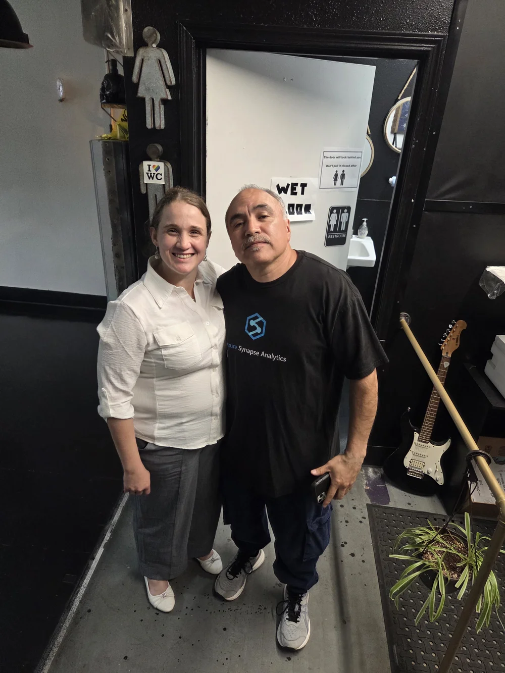Candice standing with a tattoo shop partner